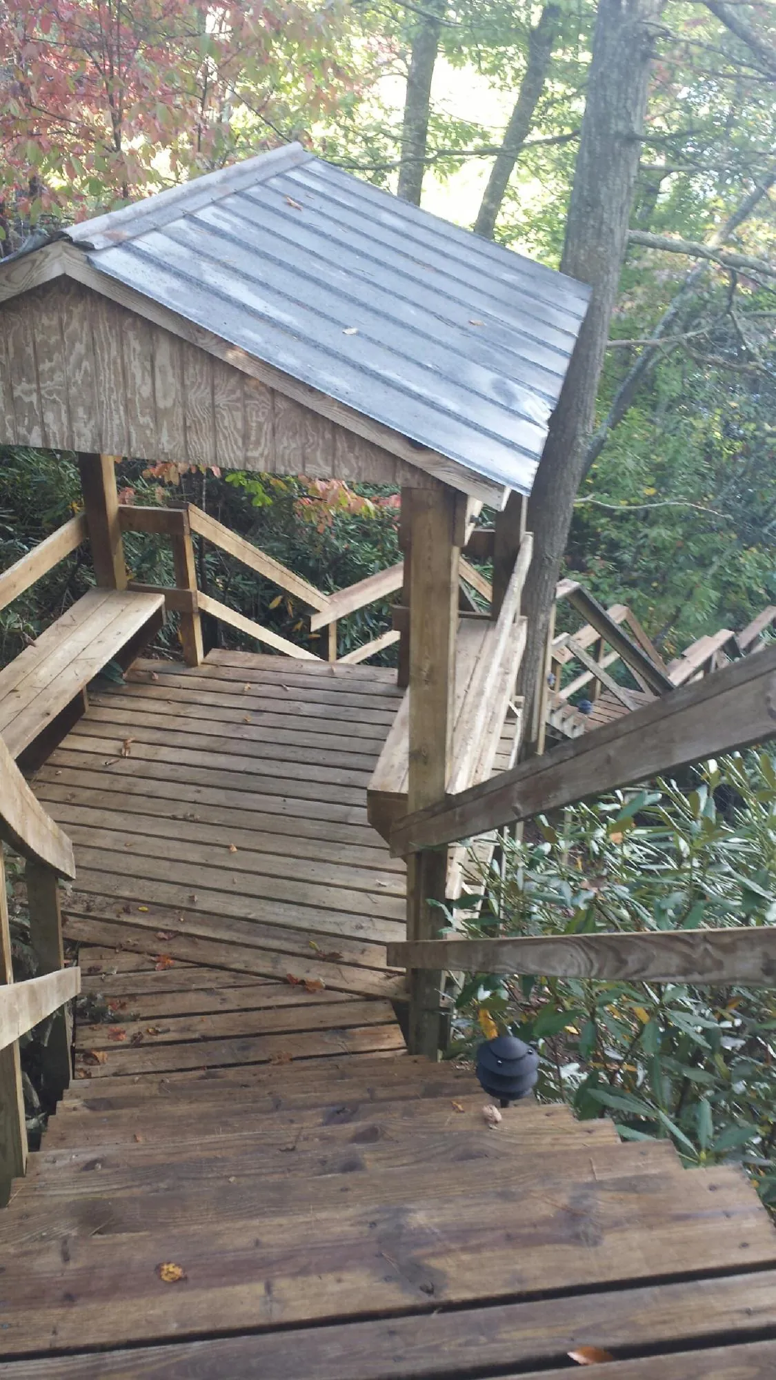 Metal roofed shelter over wooden steps on a wooded walkway — Skylight Repair & Installation work by our crew in Westerlo