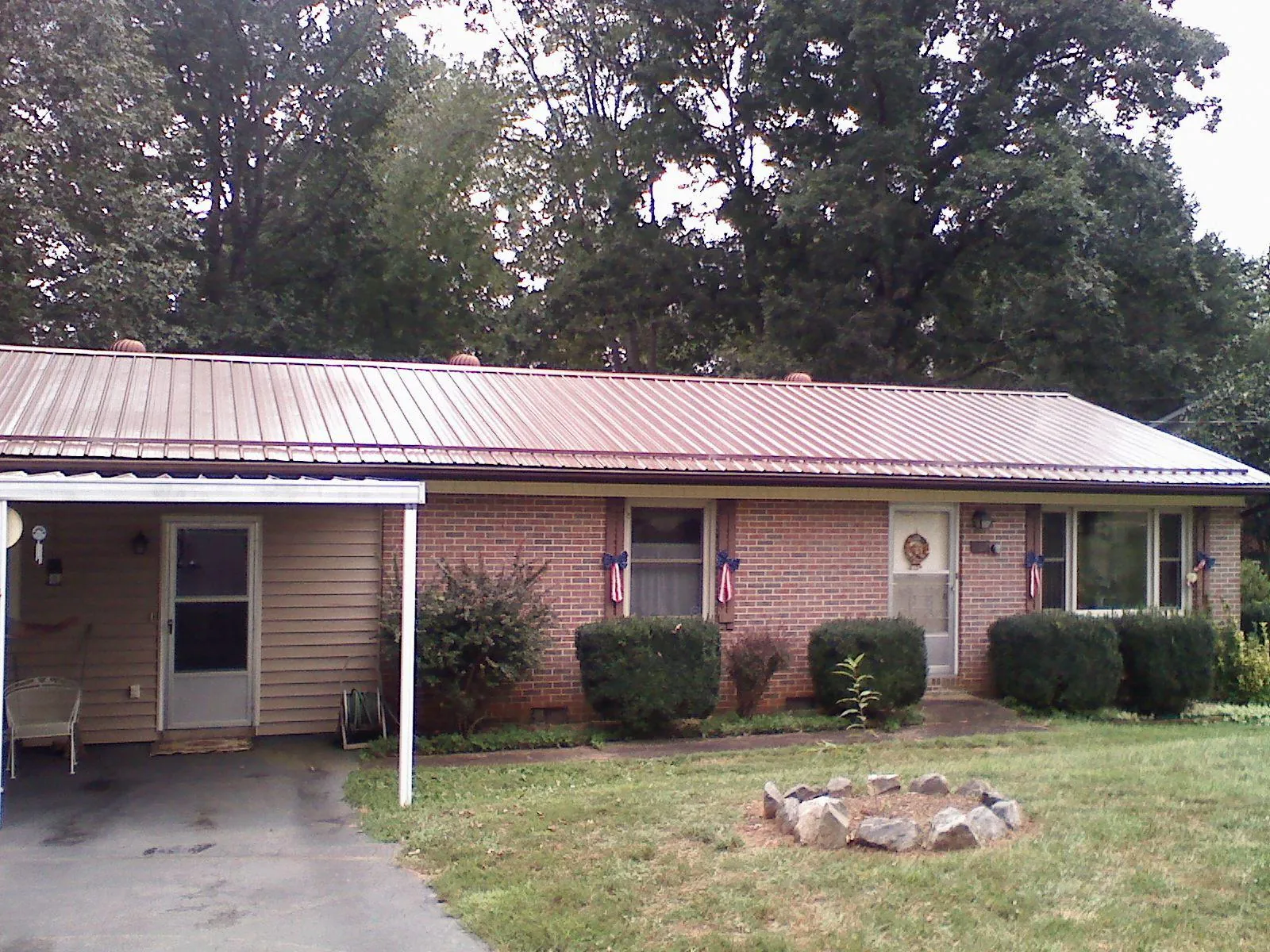 Bronze metal roof and carport on a brick ranch home — Roof Repair work by our crew in Westerlo